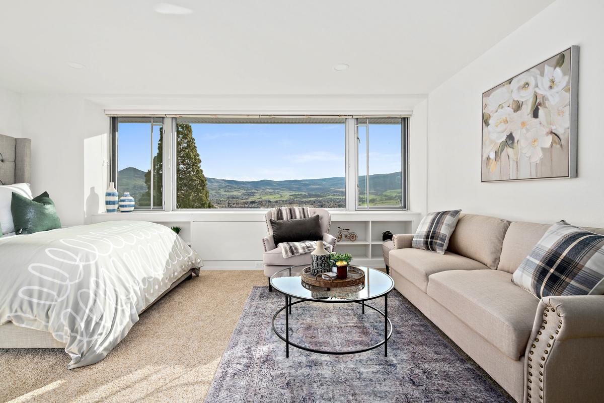 A bedroom with a seating area in a Rogue Valley Manor residence.