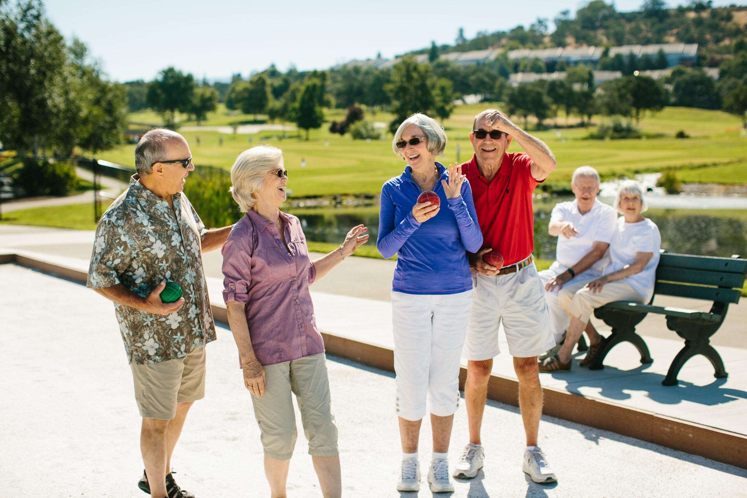 A group of friends talks and laughs after a game of Bocce.