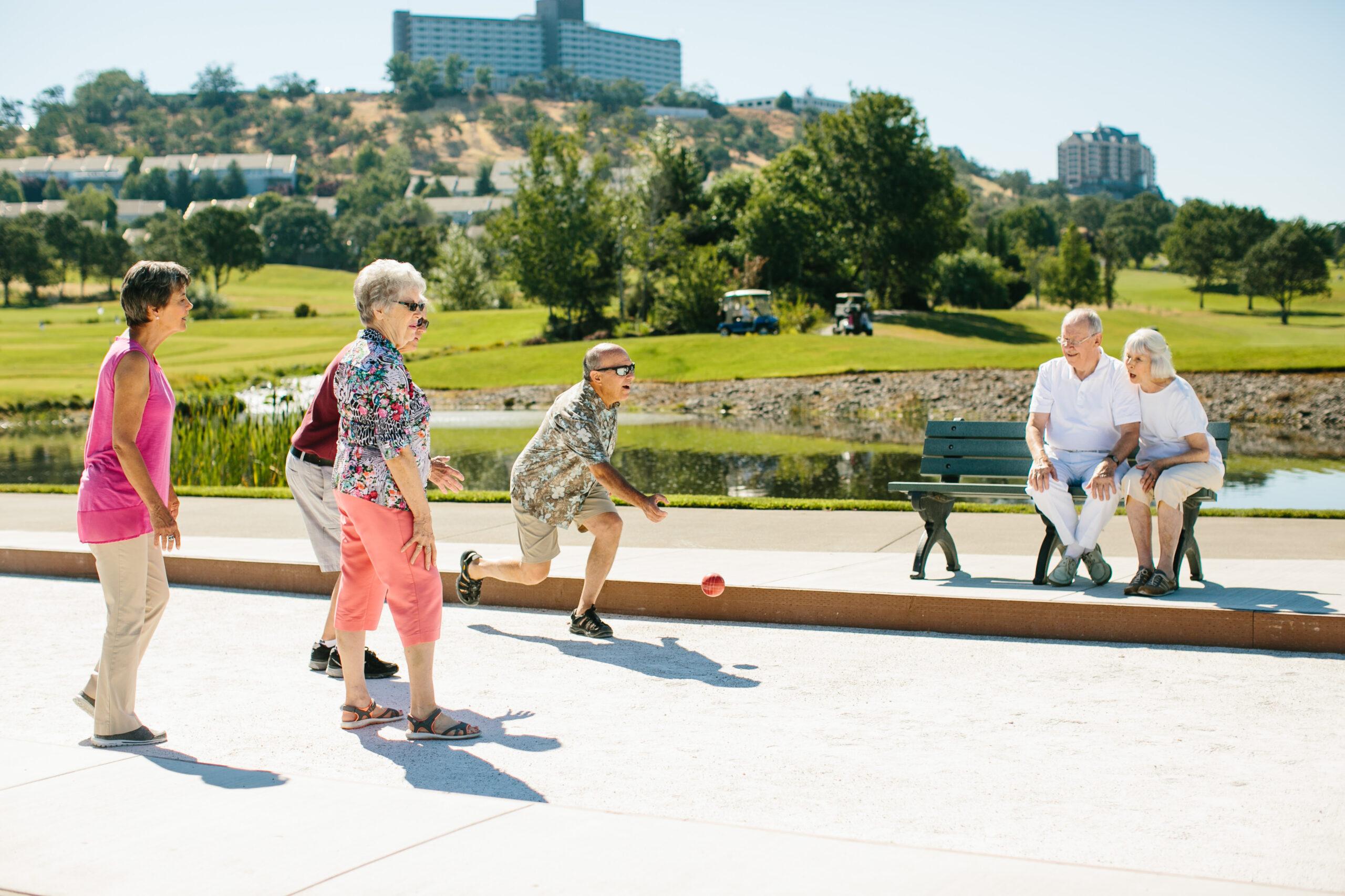 A group of friends has fun playing a game of Bocce.