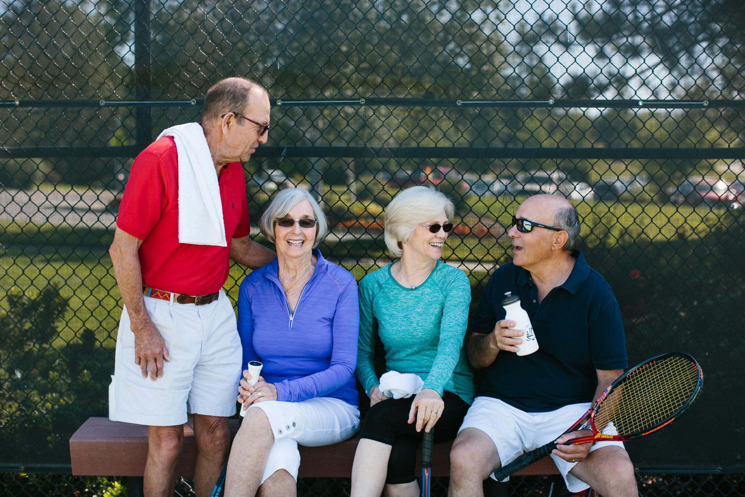 Four friend gather and relax after a game of Pickleball.