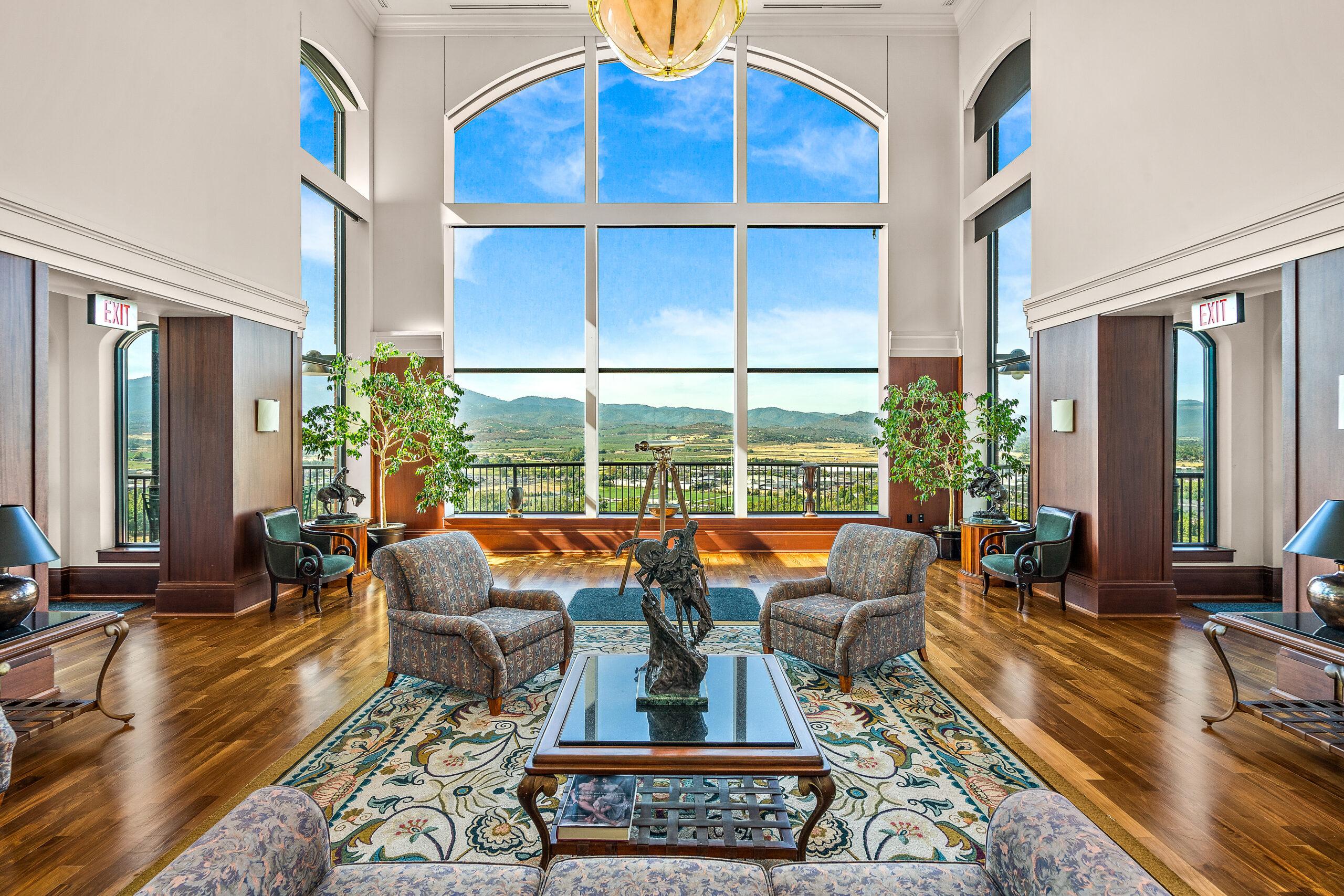 Photo of a common room in a Rogue Valley Manor residence with large windows showcasing the surrounding landscape.