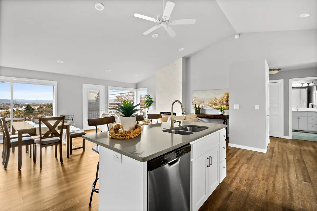 Photo of a kitchen with an island and dining room in a Rogue Valley Manor residence.
