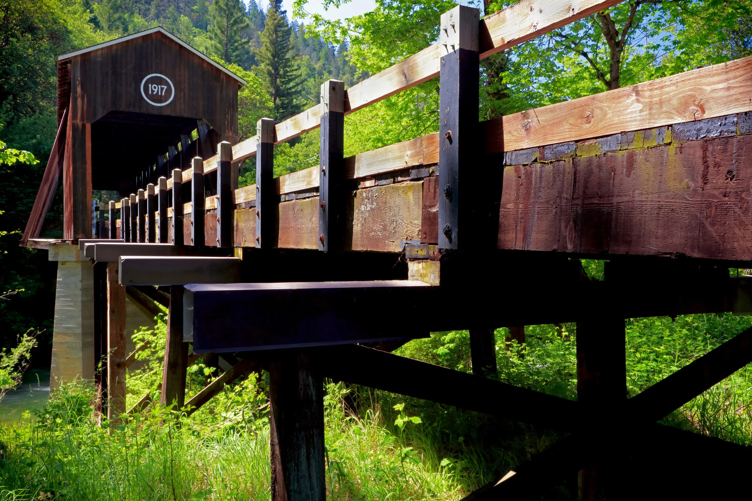 McKee Covered Bridge: photo of a wooden bridge with a covered section. "1917" is painted in white on the covered section of the bridge.